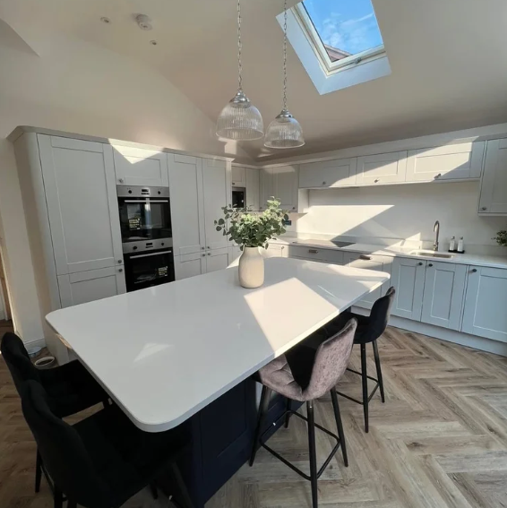 Light grey shaker kitchen with navy island, pendant lighting and skylight, fitted by JL Kitchens & Bedrooms