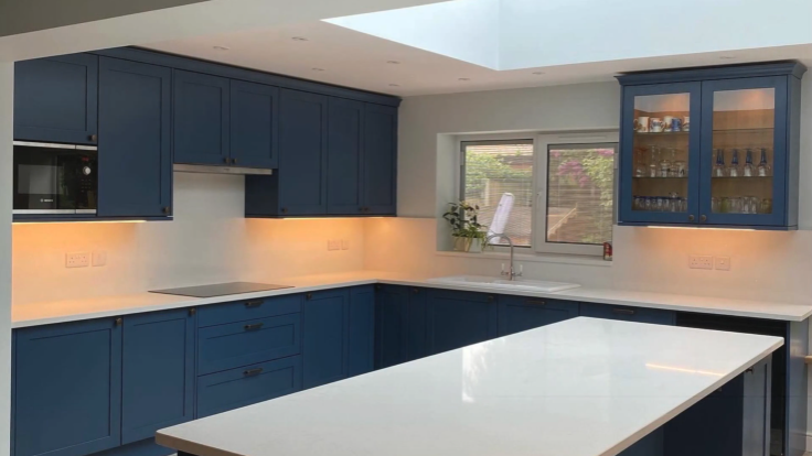 Navy blue shaker kitchen with brass hardware and a skylight, fitted by JL Kitchens & Bedrooms